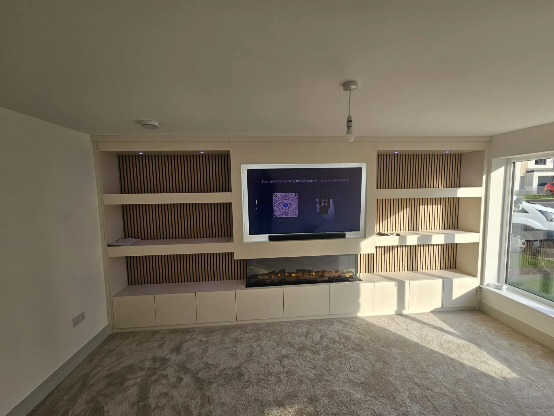 Contemporary bespoke media wall with integrated Evonic electric fireplace and LED lighting in a Scottish living room